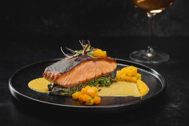 Check out this delicious, juicy salmon on a beautifully presented plate at Carversteak at Resorts World Las Vegas.