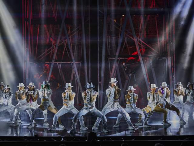 A group of performers dancing on stage during the Michael Jackson ONE show by Cirque du Soleil.