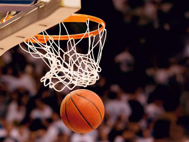 Basketball going through a basketball goal.