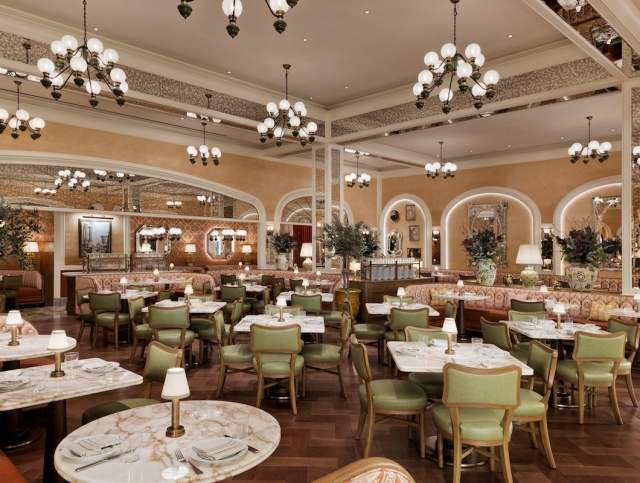 View of dining area with marble top tables, green chairs, and elegant lighting at Mother Wolf Restaurant inside Fontainebleau Las Vegas. PHOTO CREDIT CONNIE ZHOU