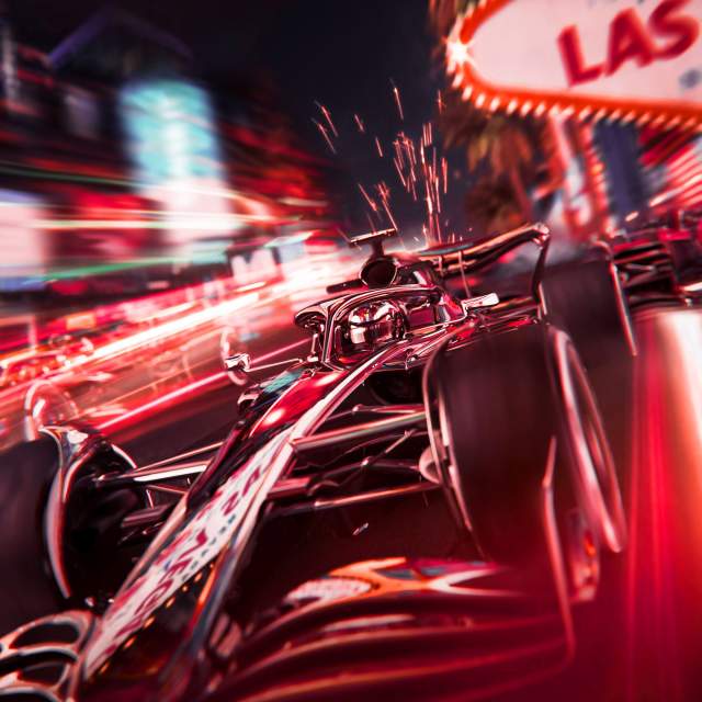 A Formula 1 car racing down the Las Vegas Strip at night