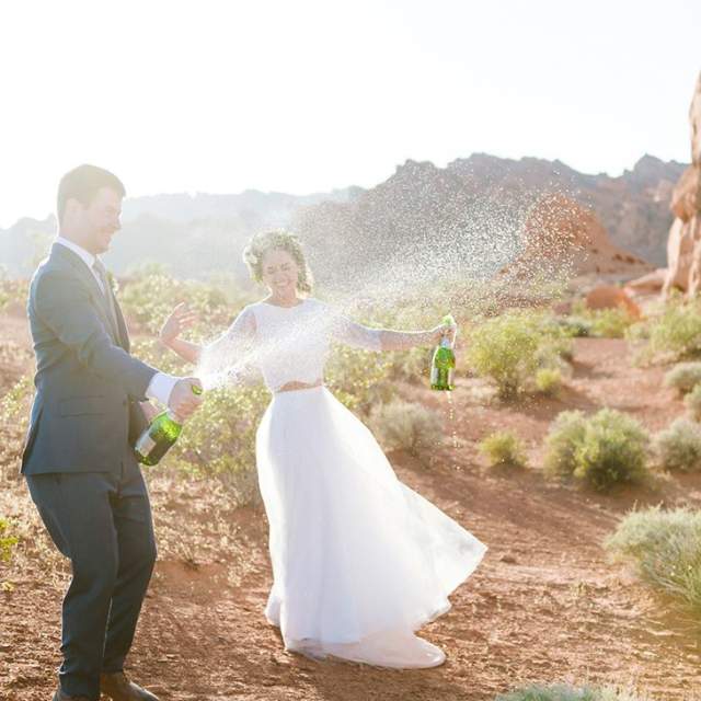Bride & groom popping champagne in the desert