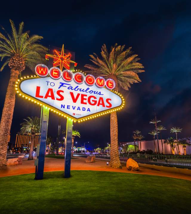 The iconic Welcome to Fabulous Las Vegas sign glowing against the night sky.
