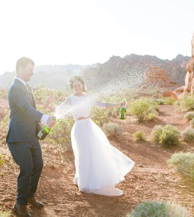 Bride & groom popping champagne in the desert