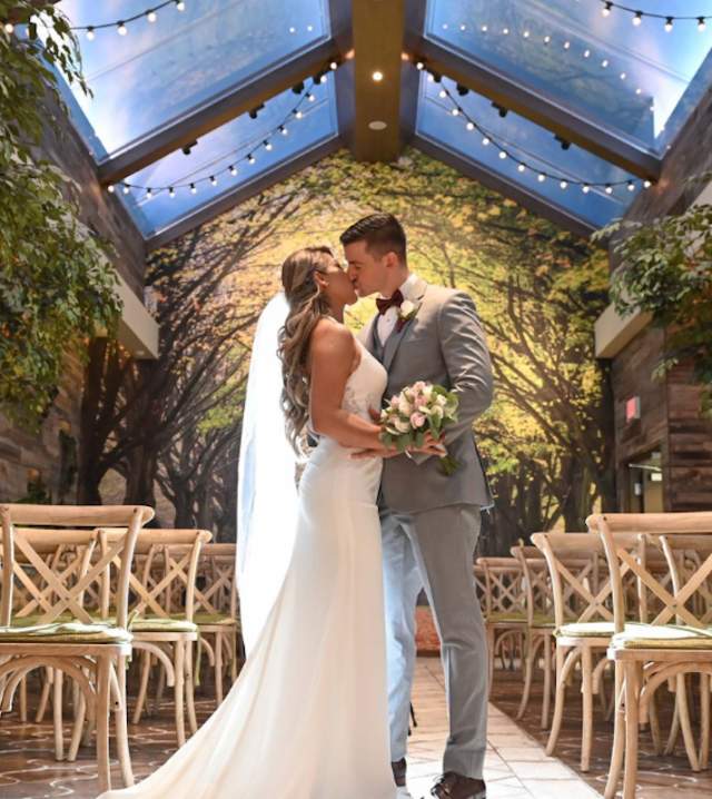 Wedding photo of a newly wed couple kissing at the Glass Garden in Chapel of the Flowers
