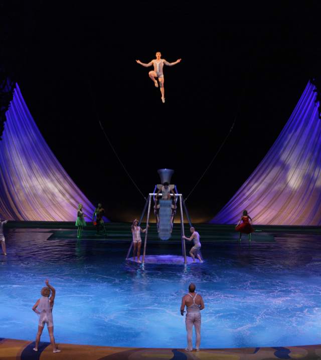 A group of performers doing stunts on stage during the O show by Cirque du Soleil.