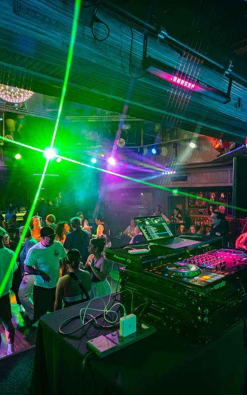 A group of people dancing in front of a DJ at Losers' Lounge at Don Laughlin's Riverside Casino & Resort.