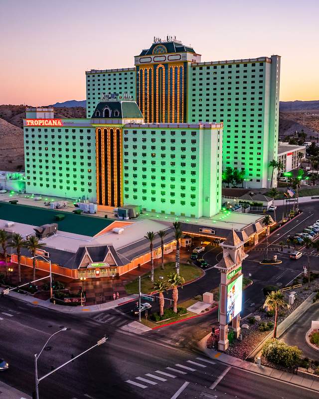 An aerial view of Tropicana Laughlin resort a dusk with the mountain range in the background.