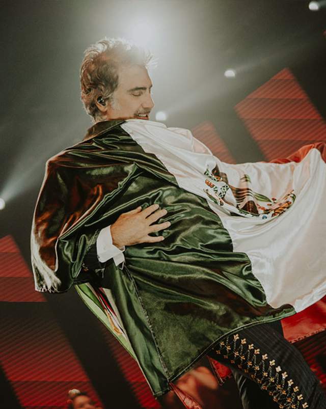 Alejandro Fernández shows pride for his country during a concert.