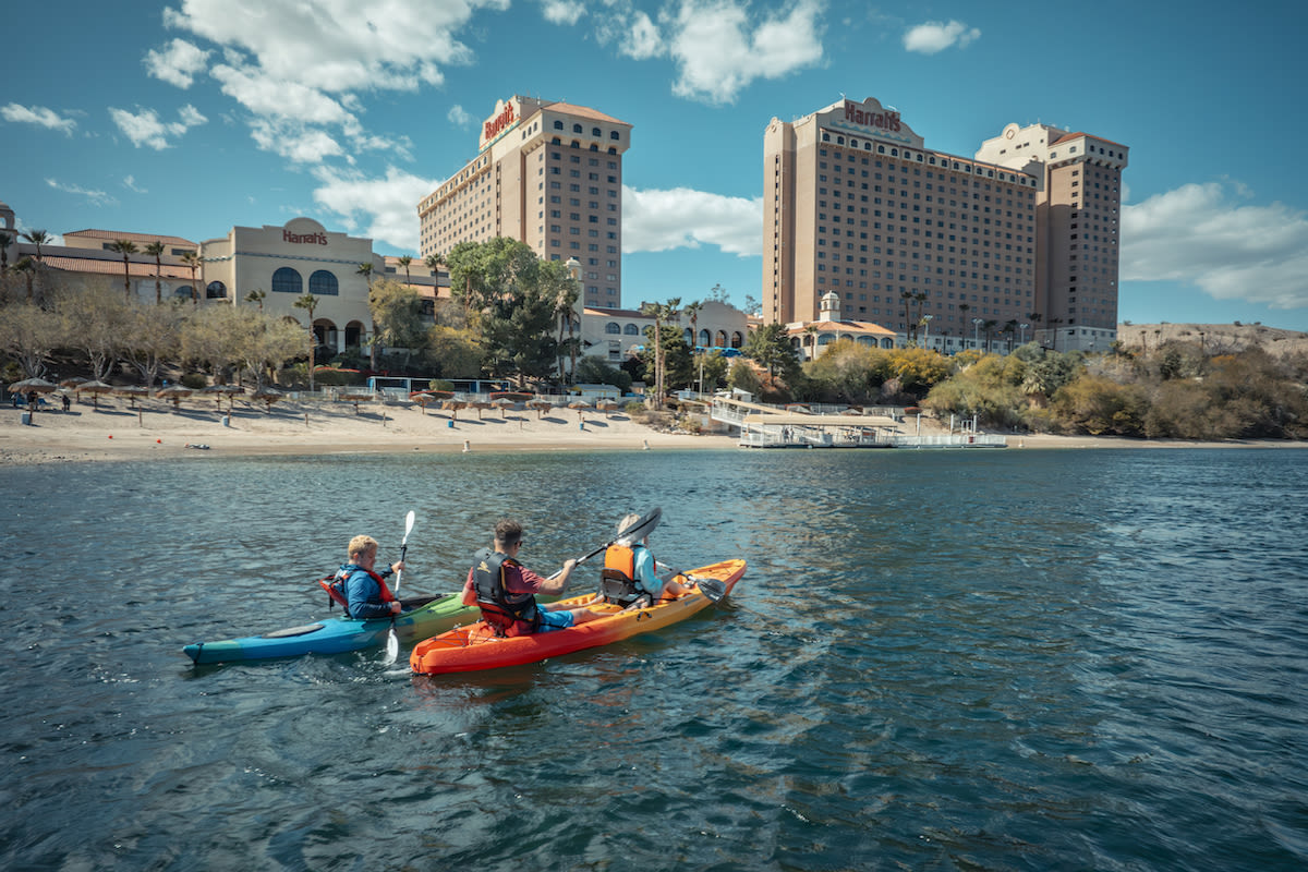 People kayaking in the Colorado River in Laughlin, Nevada with casinos in the background.