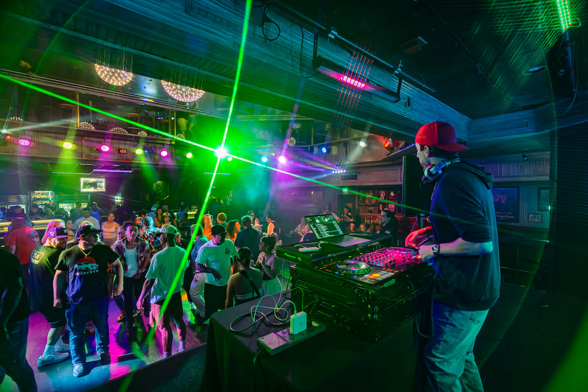 A group of people dancing in front of a DJ at Losers' Lounge at Don Laughlin's Riverside Casino & Resort.