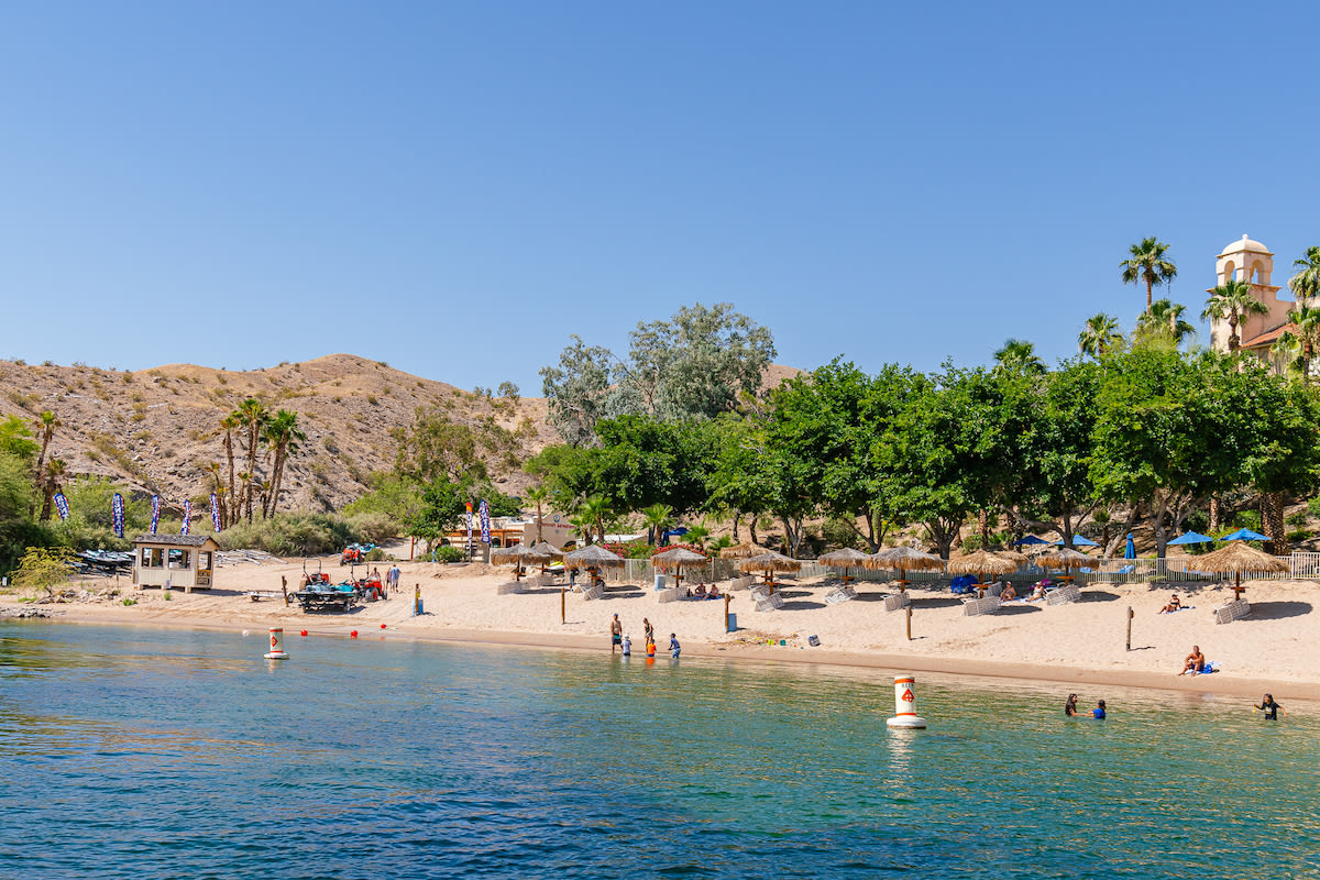 A stunning view of the beach at Harrah's Laughlin with guests enjoying the water.