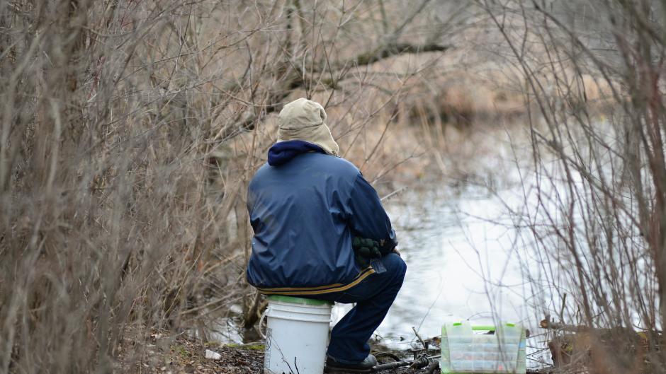 An angler fishes Reeds Lake from the bank.