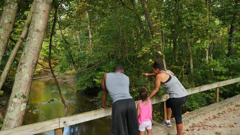 Family of three enjoying views of the river at Aman Park Trail