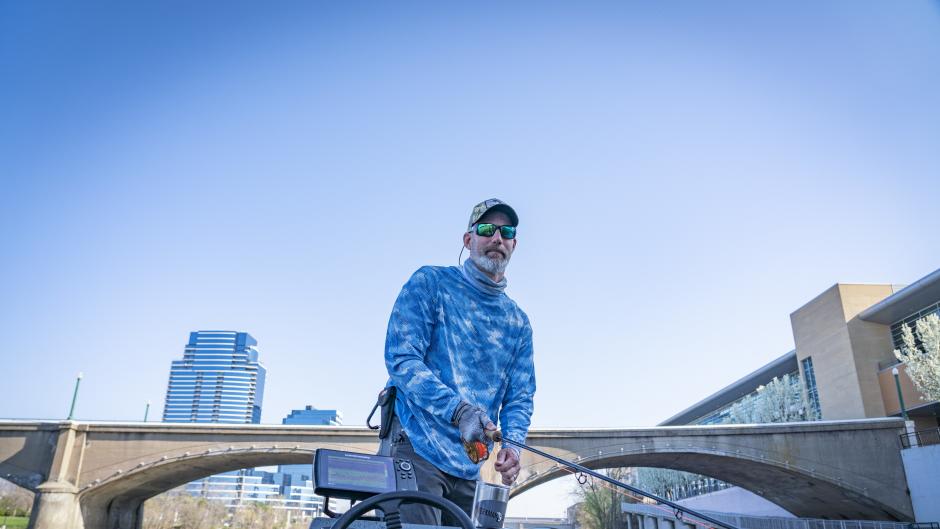 A person fishing in the Grand River in downtown Grand Rapids.