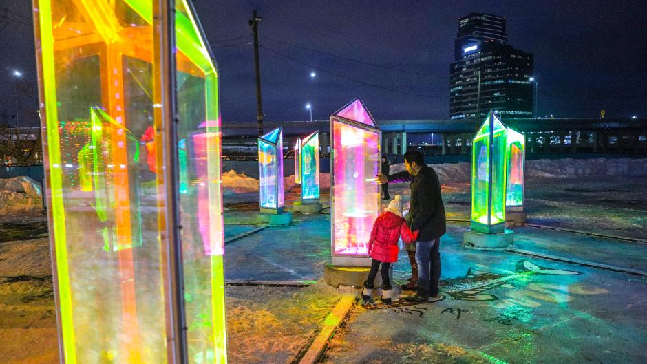 A family looking at the art installation - Prismatica on North Monroe.