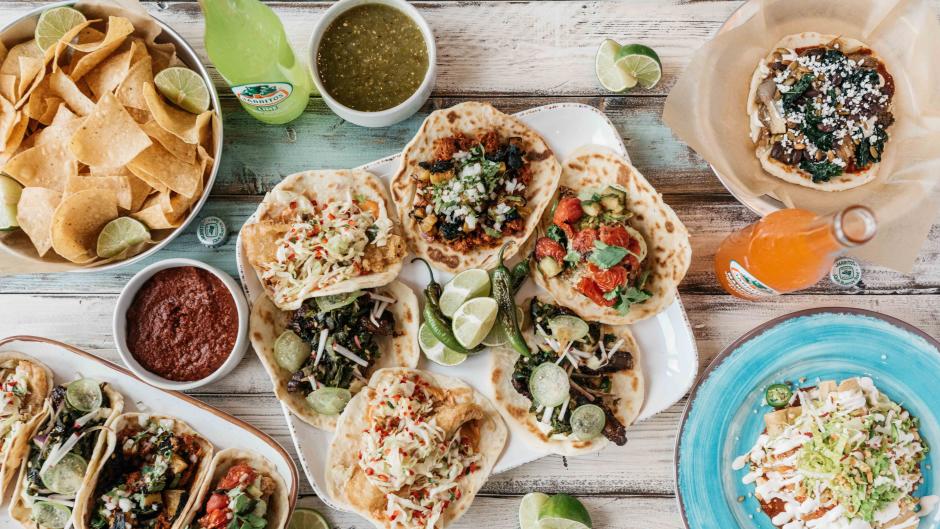 Table Covered with a Selection of Tacos, Chips, and Salsa