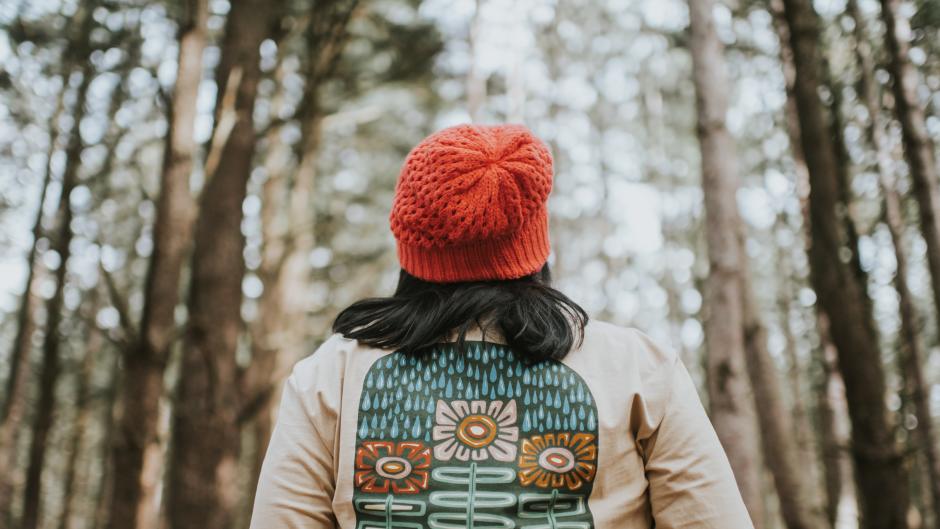 Lady hiking in the woods wearing a shirt from Woosah