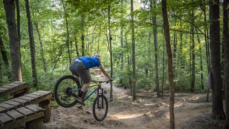 Mountain biker jumping off a platform on a trail near Grand Rapids