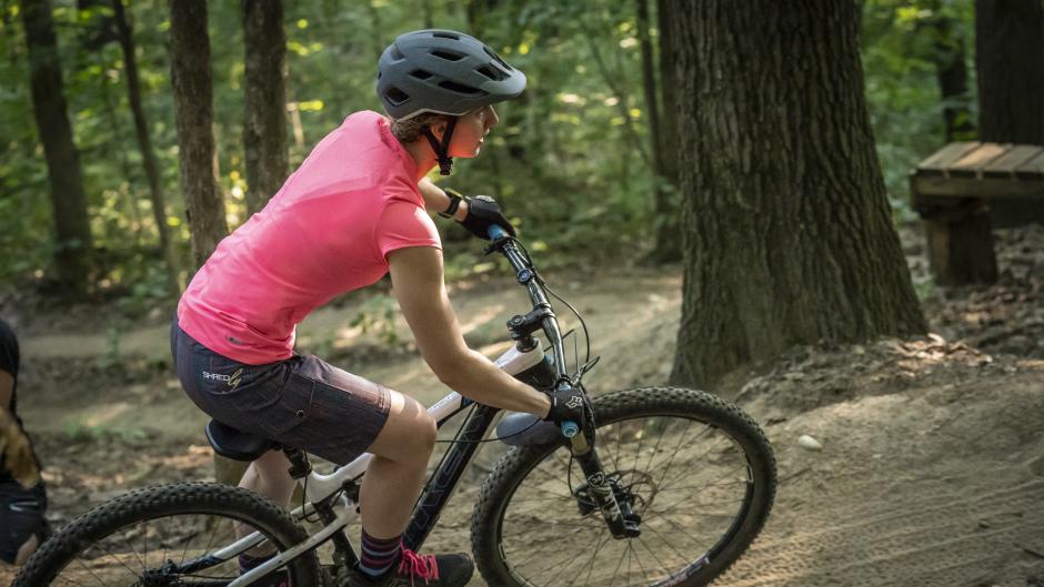 Mountain biker with a pink shirt on a trail just outside of Grand Rapids