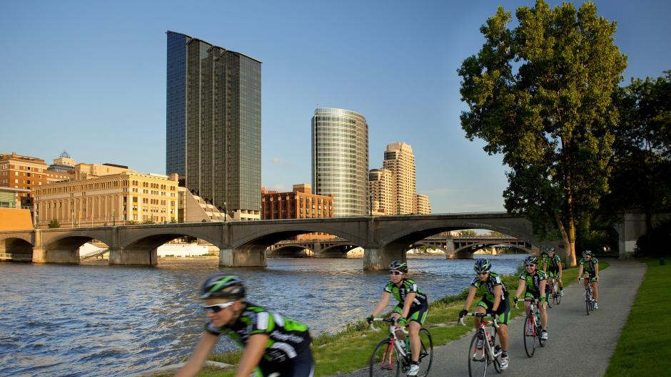 Bikers cycling through Downtown Grand Rapids along the river