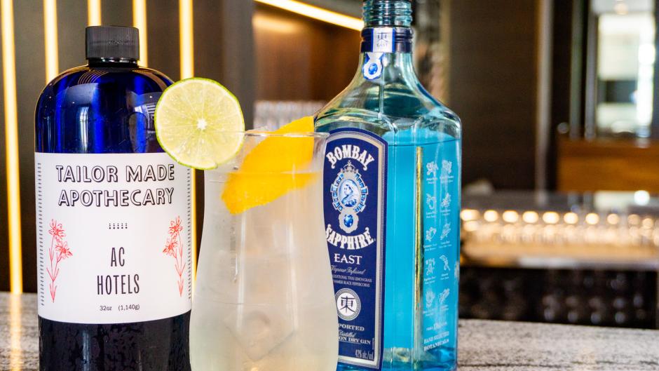 A Gin and Tonic cocktail with gin and tonic sitting behind it.