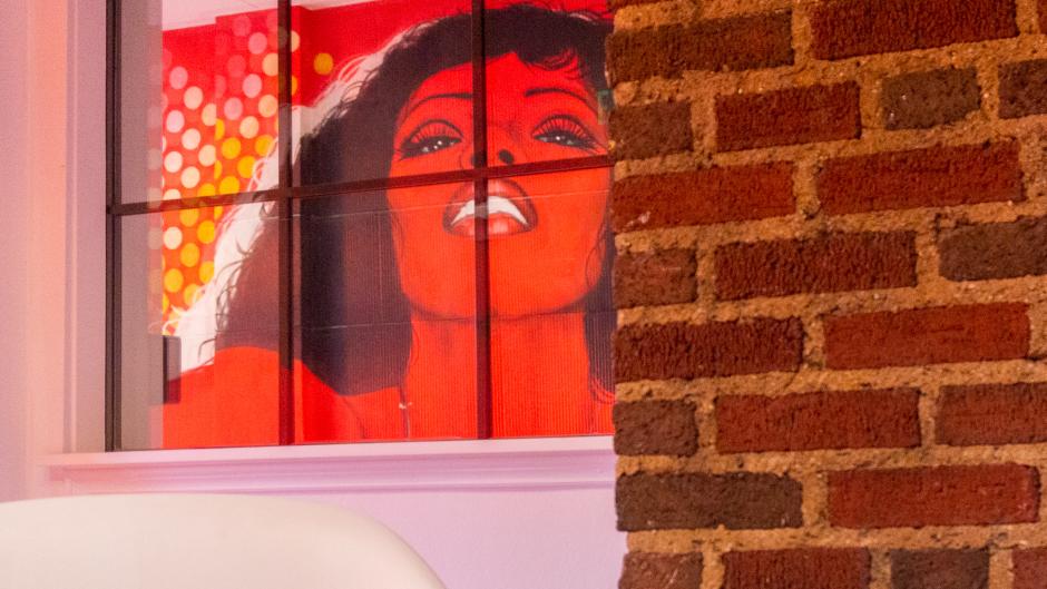A painting of a red-hued woman at IDC.