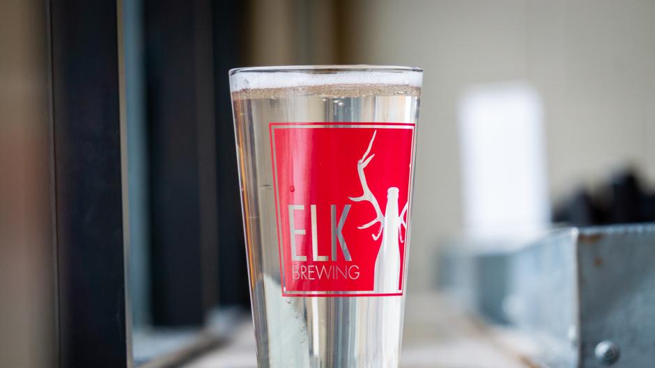 A branded pint glass full of hard seltzer from Elk Brewing.