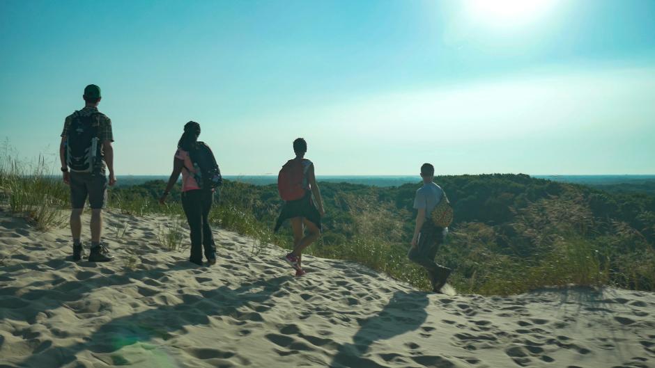 Four people hiking in sand at PJ Hoffmaster State Park near Grand Rapids