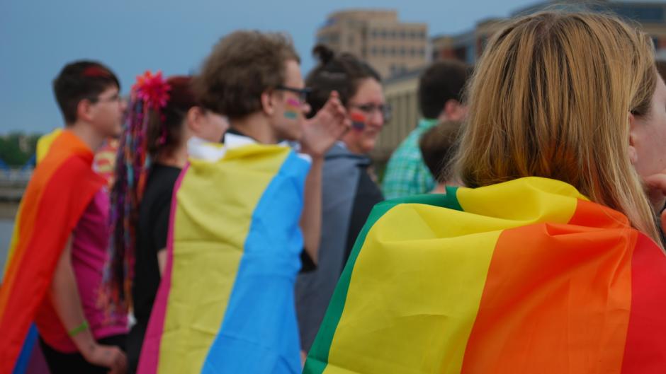 Several Pride Festival Attendees in Grand Rapids wearing Pride Flags as capes