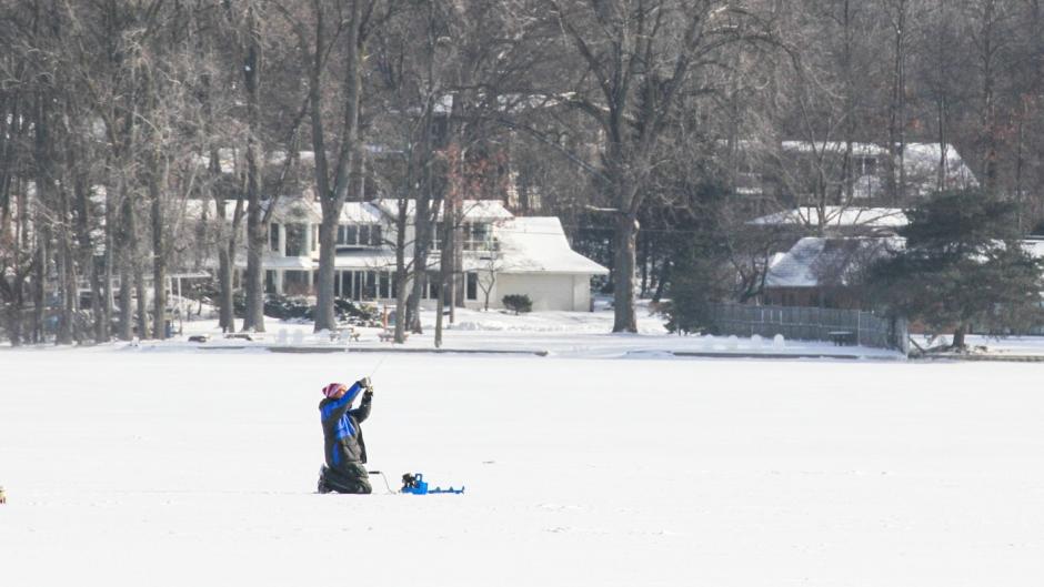 Person ice fishing on Reed's Lake.