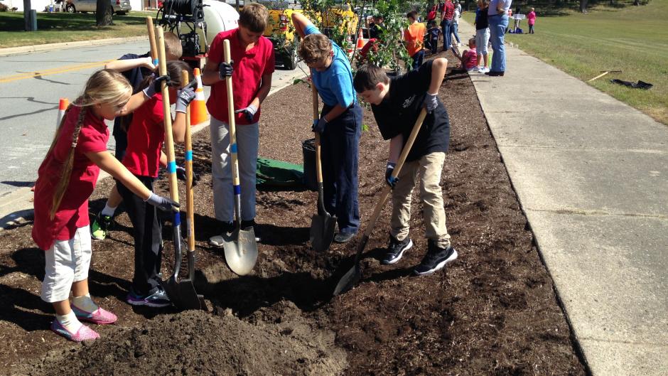 Kids and adults of all ages planting trees with Lower Grand River Organization of Watersheds (LGROW).