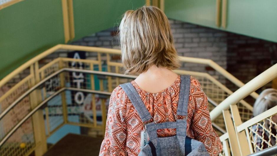 Child with backpack walking down stairs at the Grand Rapids Children's Museum