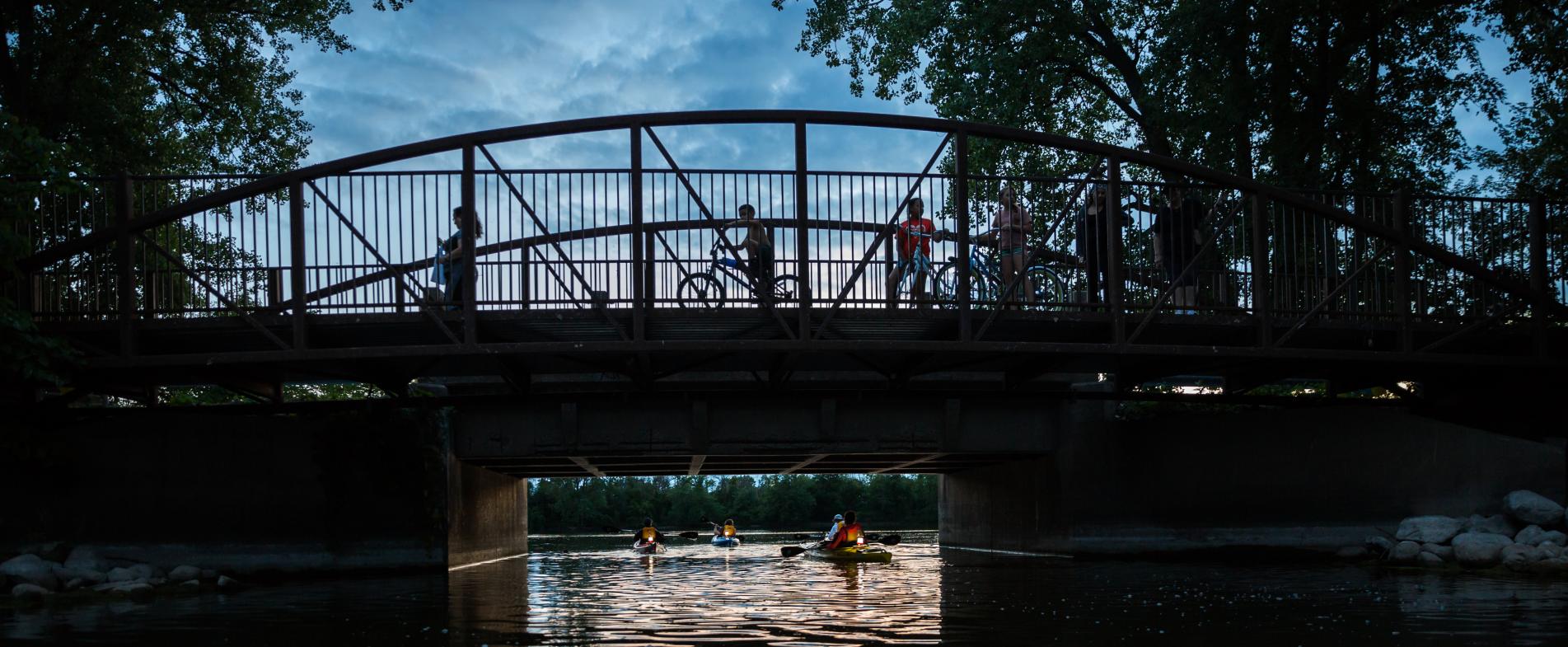 Paddlers enjoying kayaking at nighttime at Riverside Park.