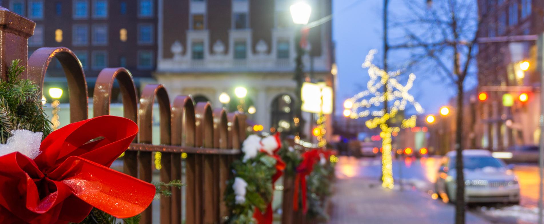 Fence decorated with bows and garland for the holidays.
