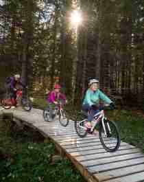 A family of four is biking through the woods in Trysil bike arena in Trysil, Eastern Norway