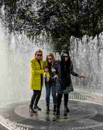 Four laughing women standing in the fountain surrounded by mirrors at Kistefos Museum in Hadeland