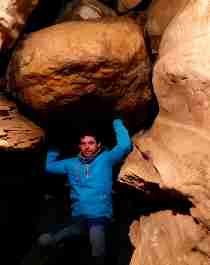 En mand står inde i Grønligrotta-hulen i Helgeland, Nord-Norge