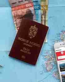 Planlegg reisen til Norge: Et kart, pengesedler, en mobillader og en mobiltelefon med Visit Norway-appen