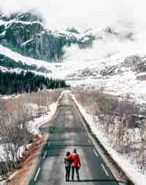 A couple on a road in a winter-clad Lofoten, Northern Norway