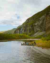 En gruppe mennesker er samlet omkring to både i Lyngenfjord, Nord-Norge