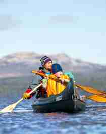 Padre e hijo montan en canoa durante una aventura en plena naturaleza para toda la familia en Femund Engerdal, Noruega.