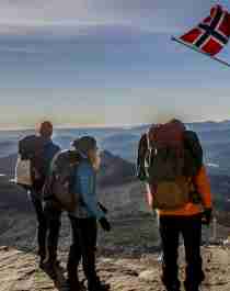 Menschen genießen am Gipfel des Gaustatoppen die Aussicht an einem sonnigen Tag