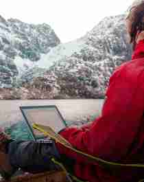 En mann jobber utendørs på Arctic Coworking Lodge i Lofoten, Nord-Norge