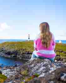 A woman looking at the view of Børhella lighthouse at Andøya, Northern Norway
