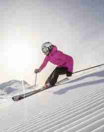 En dame står på ski ned en slalåmbakke i Hemsedal på Østlandet