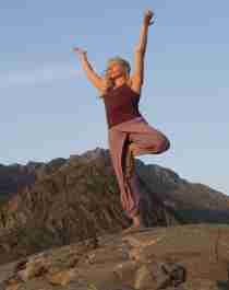 En dame som gjør yoga mens hun er på topptur