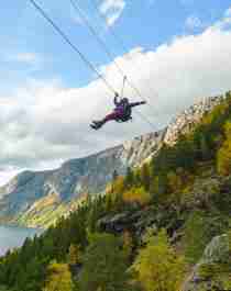 Woman sliding down a zipline near Trolltunga in Fjord Norway