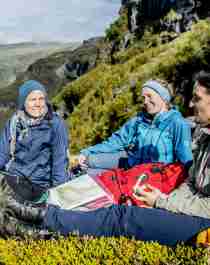 Plan your trip to Norway. People with maps resting in the Aurlandsdalen valley