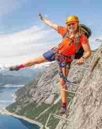 Active holiday in Norway: Woman climbing the Trolltunga via ferrata in Fjord Norway